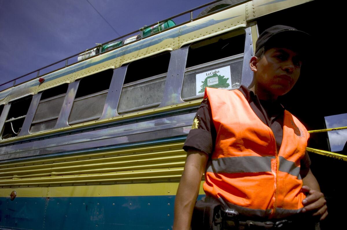 Un agente de la Policía Nacional Civil (PNC) de la división de explosivos vigila un autobús en la zona norte de Ciudad de Guatemala.