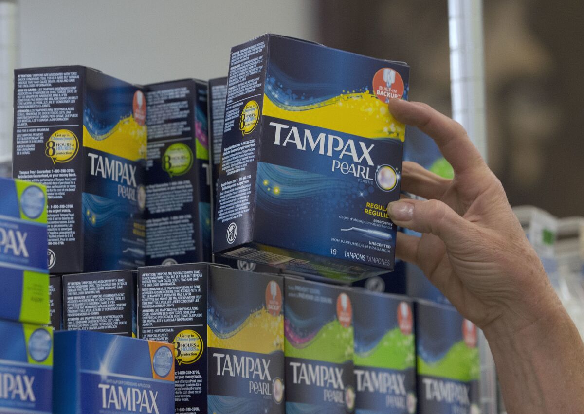 FILE - In this June 22, 2016 file photo, Tammy Compton restocks tampons at Compton's Market, in Sacramento, Calif. California public schools and colleges must stock their restrooms with free menstrual products under a new law signed by Gov. Gavin Newsom, Friday, Oct. 8, 2021. (AP Photo/Rich Pedroncelli, File)