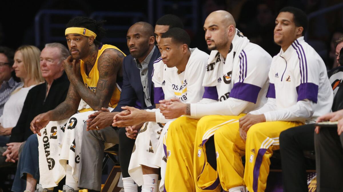 Injured Lakers star Kobe Bryant, second left, sits with his teammates on the bench during a win over the Detroit Pistons at Staples Center on March 10.