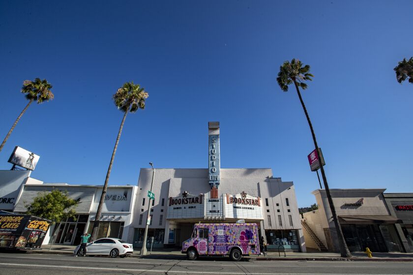 STUDIO CITY, CA - JULY 25: A pink vegan food truck is parked in front of the former Fox Studio City Theatre, now a bookstore, on Saturday, July 25, 2020 in Studio City, CA. Many people are now out on urban hikes during the pandemic. (Brian van der Brug / Los Angeles Times)