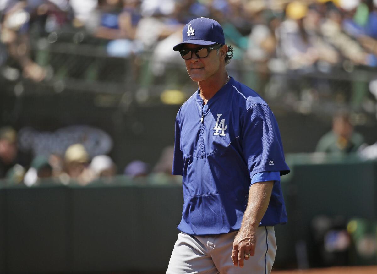 Dodgers Manager Don Mattingly walks back to the dugout after a pitching change in the sixth inning of a game against the Oakland Athletics on Aug. 19.