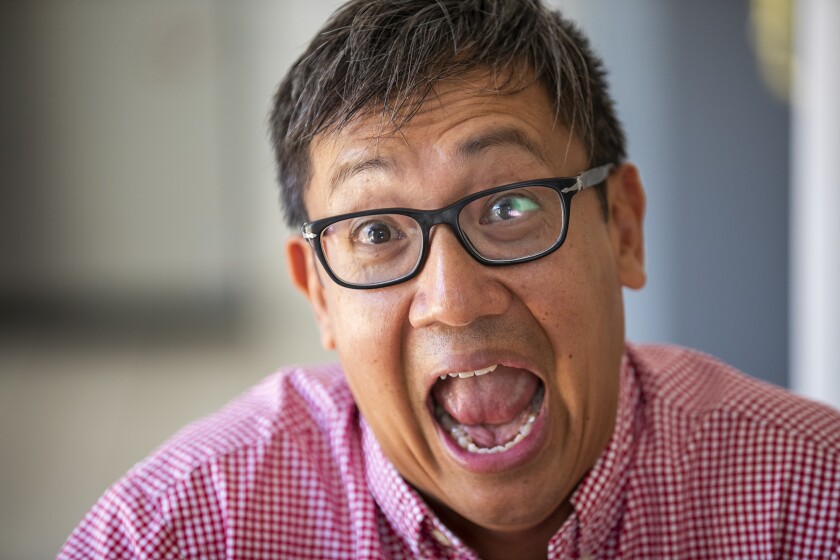 Foo Nguyen yucks it up for the camera at his home in Irvine.