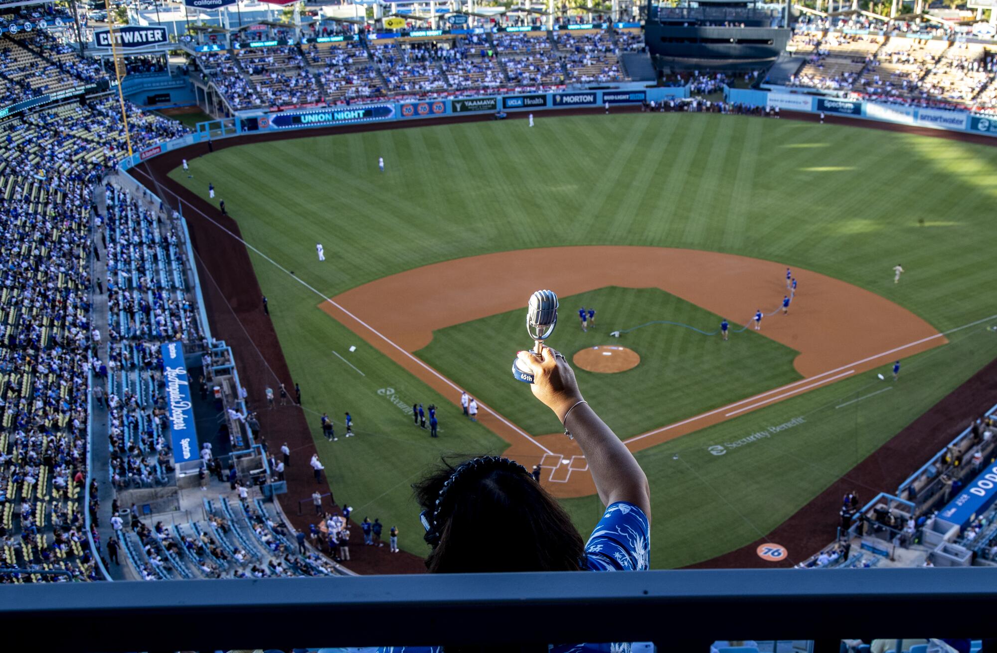 Dodgers fan Angie Varella holds a replica microphone during a tribute to late Dodgers announcer Vin Scully.