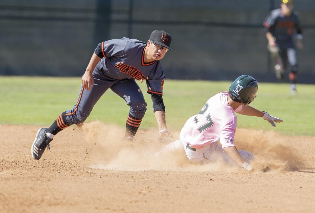 Edison High's Caden Aoki, pictured sliding into second base against Huntington Beach's Cole Minato on May 8, 2018, threw a one-hitter in a 3-0 win over Mater Dei Thursday.