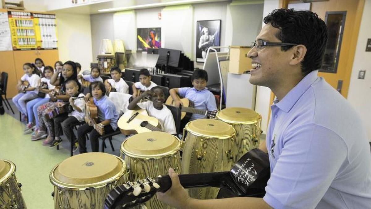El maestro de música Bladimir Castro toca la guitarra durante su clase en Carlos Santana Arts Academy en North Hills. El campus es un torrente de artes visuales y escénicas, pero el director ha tenido que salir fuera del distrito escolar para obtener ayuda.