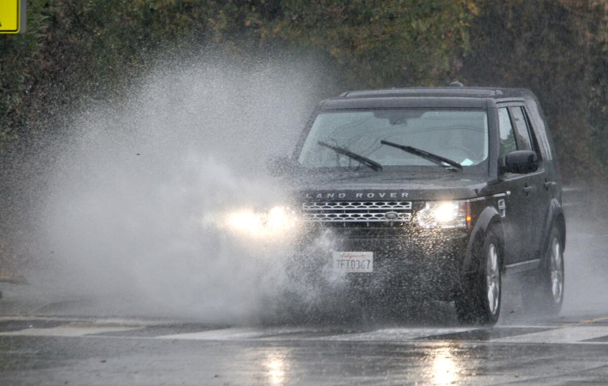 A Range Rover hits a large pool of water on the 1500 block of Verdugo Blvd. in La Cañada Flintridge on Tuesday, Jan. 5, 2016. A predicted storm arrived in the morning and will continue through the week.
