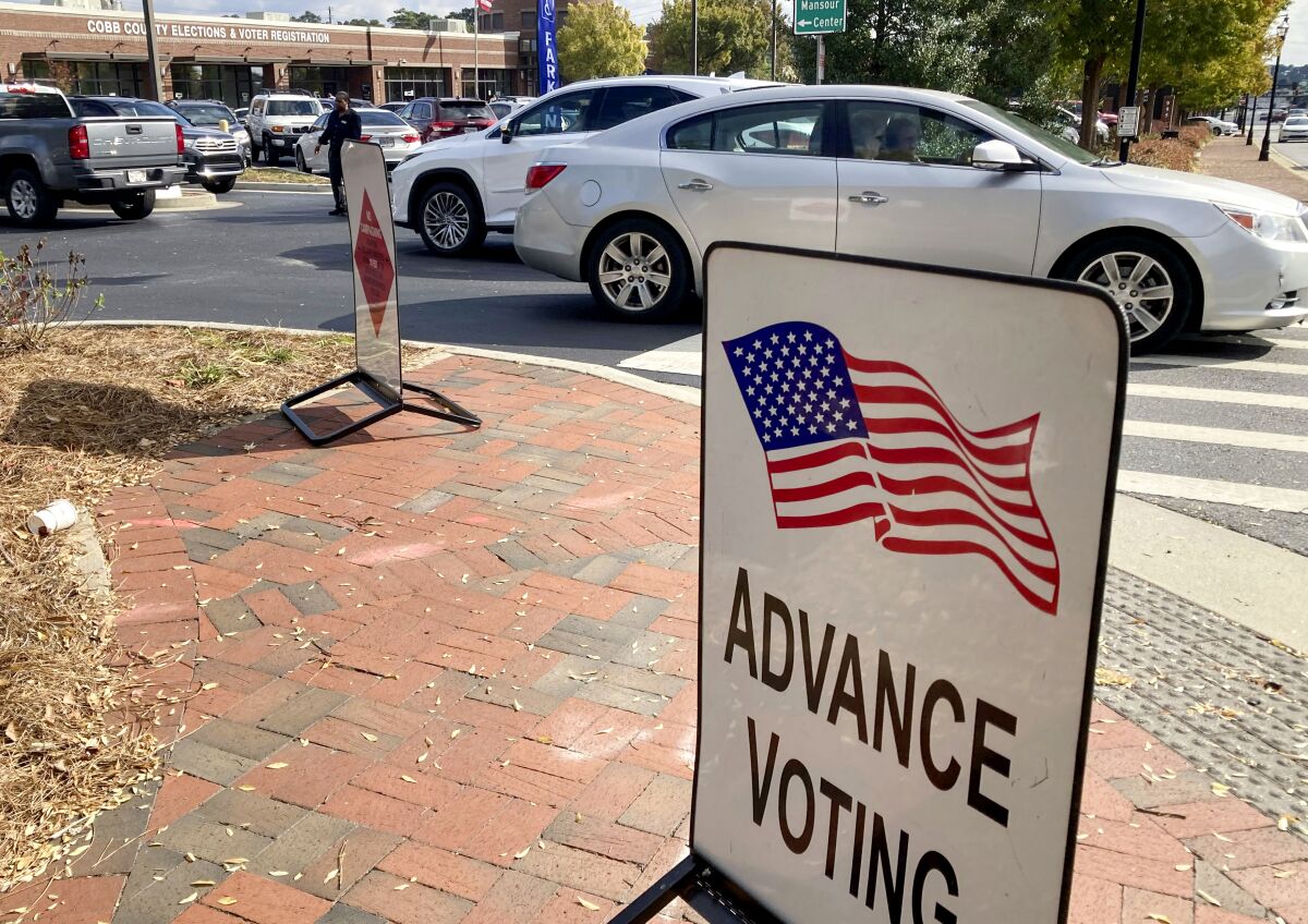 A sign showing the way for voters outside a Cobb County voting building during early voting in Marietta, Ga.