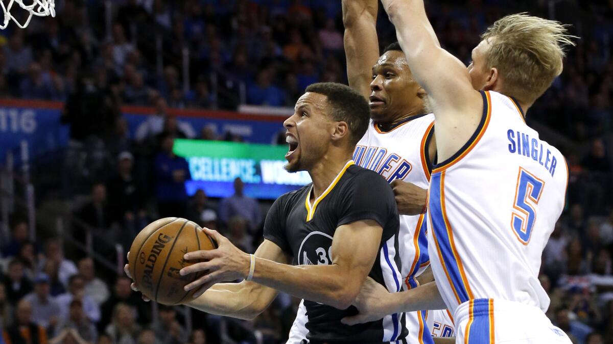 Warriors point guard Stephen Curry tries to score on a layup against Thunder forwards Kevin Durant and Kyle Singler during the first half Saturday night.