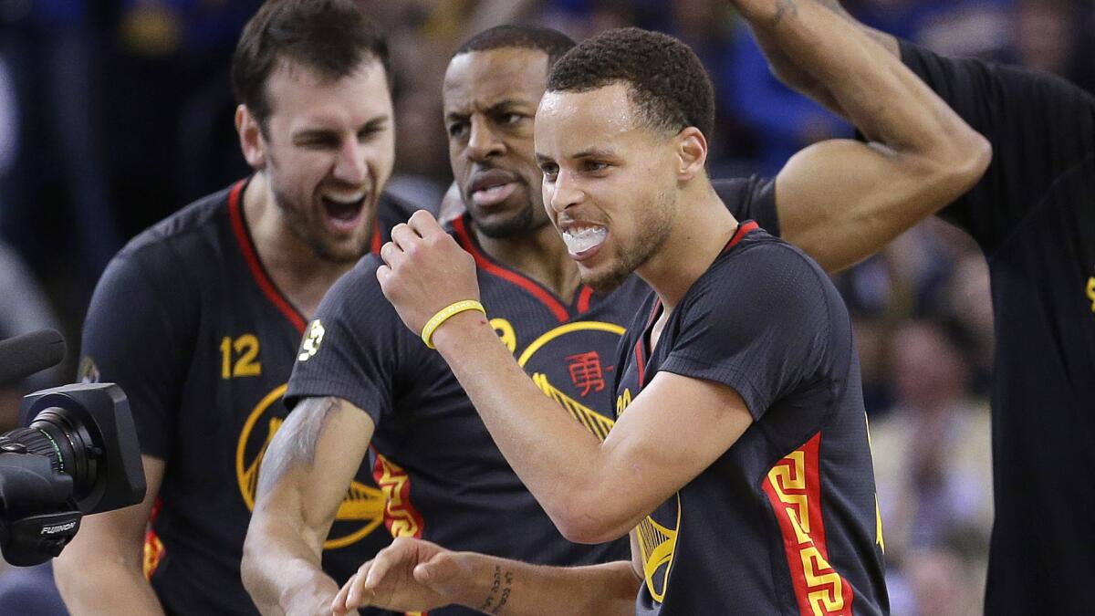 Golden State Warriors teammates (from left) Andrew Bogut, Andre Iguodala and Stephen Curry celebrate after taking the lead during a 110-99 win over the San Antonio Spurs on Friday.