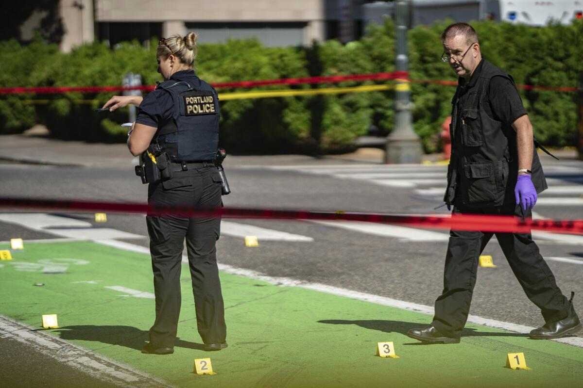 FILE - Police investigate an overnight fatal shooting in Portland, Ore., on July 17, 2021. The city's mayor on Thursday, July 21, 2022, declared a state of emergency due to spiking gun violence, with the goal to reduce fatal shootings by 10% over the next two years. (Mark Graves/The Oregonian via AP, File)