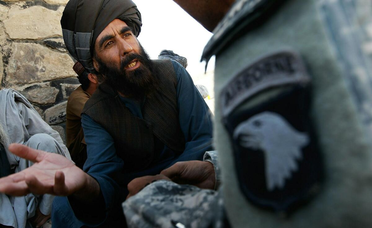 An Afghan Pashtun tribal elder makes his case with an unidentified interpreter for the Army's 101st Airborne Division during an informal meeting in 2010 west of Kandahar, Afghanistan.