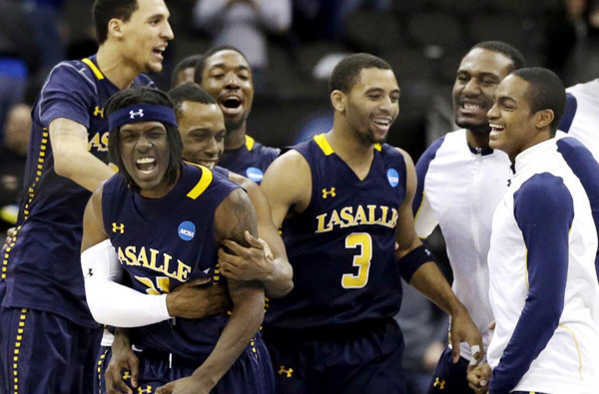 Tyrone Garland, second from left, celebrates with Tyreek Duren (3) and other teammates after hitting a layup with two seconds left to help La Salle defeat Mississippi, 76-74, in the third round of the NCAA tournament on Sunday.