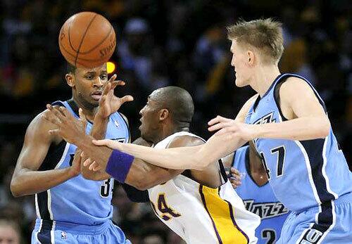 Lakers guard Kobe Bryant loses control of the ball between the defense of Utah's Andrei Kirilenko (47) and C.J. Miles in the first half.