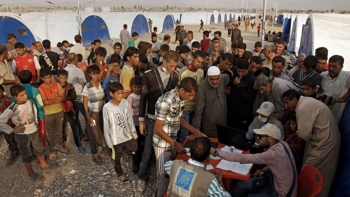 Residents who fled the fighting in Mosul line up for aid from the World Food Program.