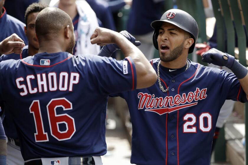 Minnesota Twins' Eddie Rosario (20) celebrates his solo home run in the dugout with teammate Jonathan Schoop (16) during the eighth inning of the team's baseball game against the Los Angeles Angels on Thursday, May 23, 2019, in Anaheim, Calif. (AP Photo/Marcio Jose Sanchez)