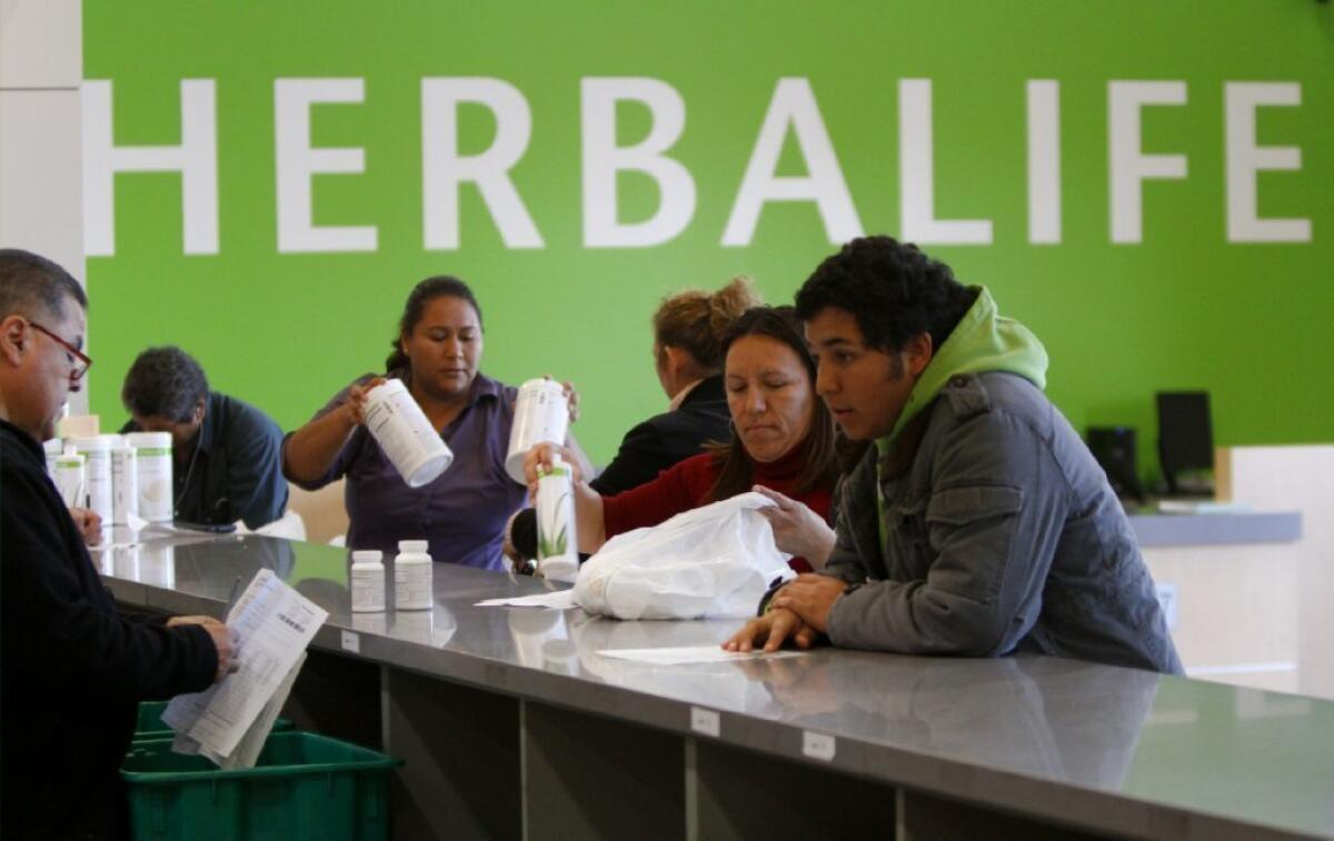 Distributors pick up Herbalife products at a distribution center in Carson earlier this year.