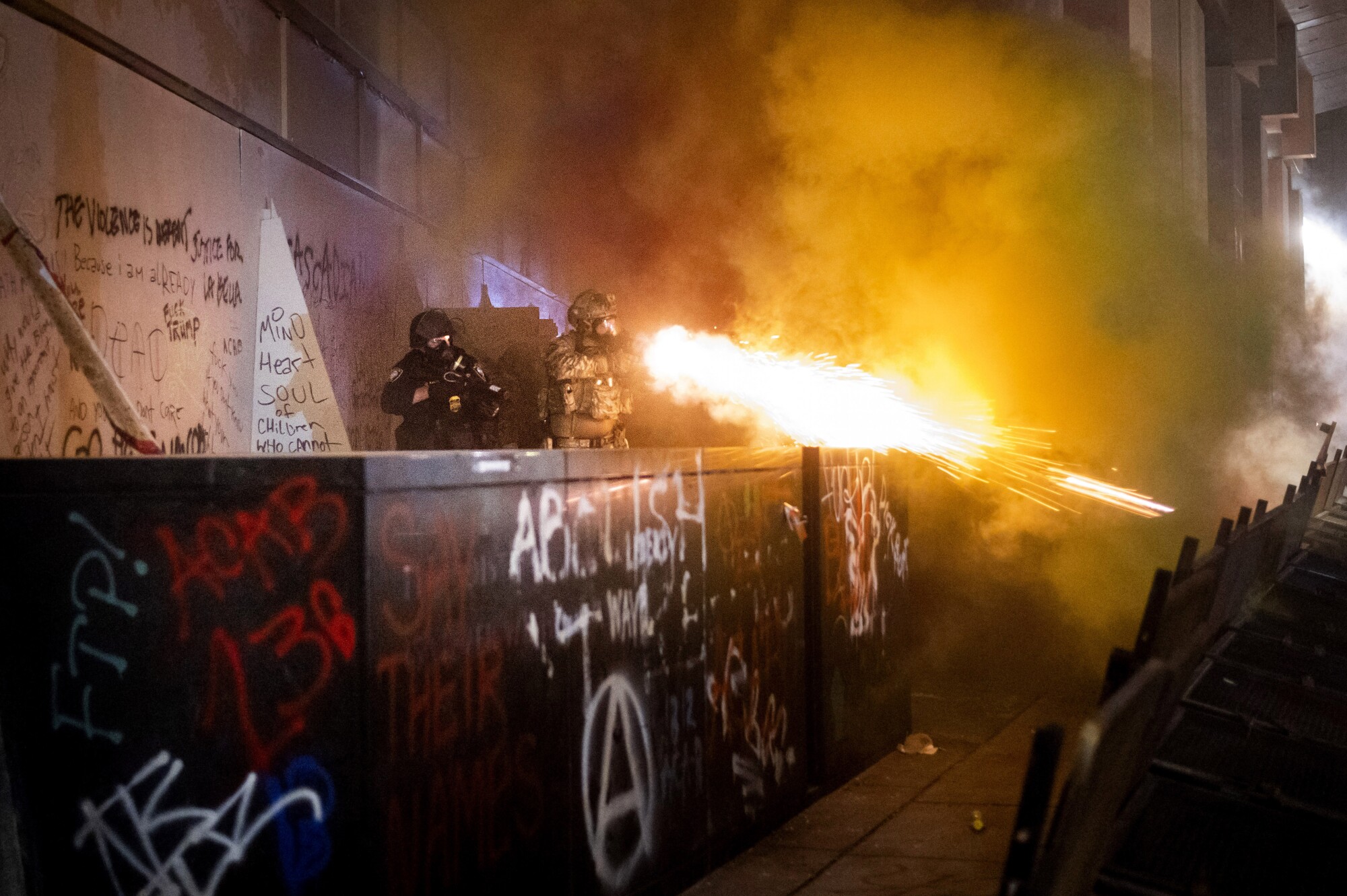 Federal agents use crowd-control munitions to disperse protesters on Sunday.