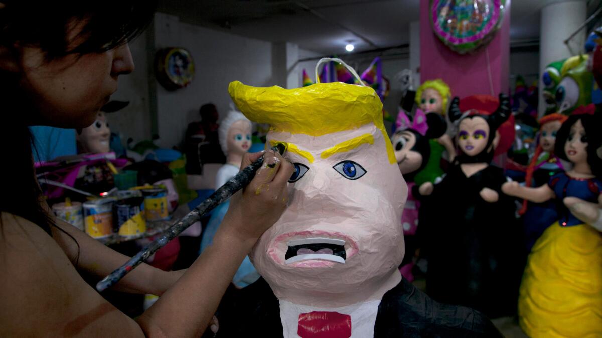 Alicia Lopez Fernandez paints a piñata of Donald Trump at her family's store in Mexico City.