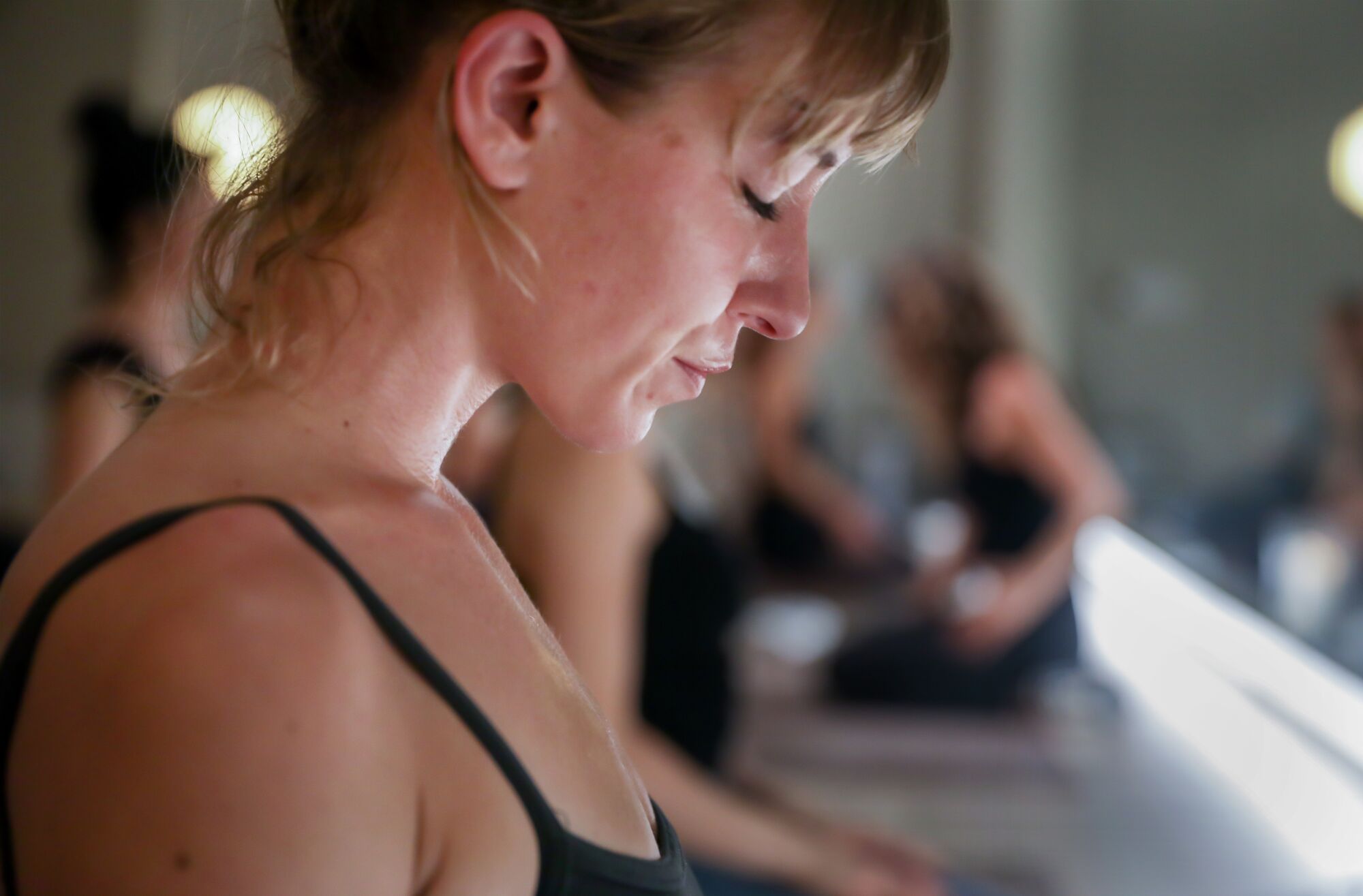 A close-up of a woman with her eyes closed in an exercise class