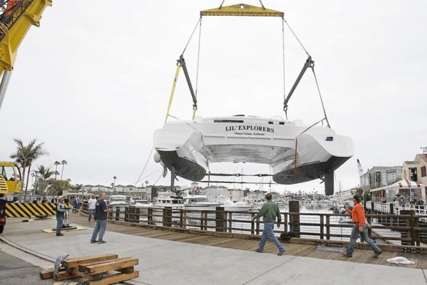 Lil' Explorers, a 58 foot long and 29 foot wide catamaran, is lifted into Newport Bay on Thursday, Jan. 24.
