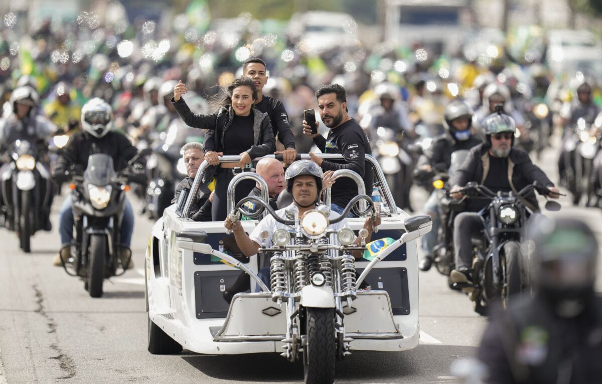 Supporters of Brazil's President Jair Bolsonaro take part in a caravan of thousands of motorcycle enthusiasts who gathered in a show of support for him in Sao Paulo, Brazil, Friday, April 15, 2022. (AP Photo/Andre Penner)