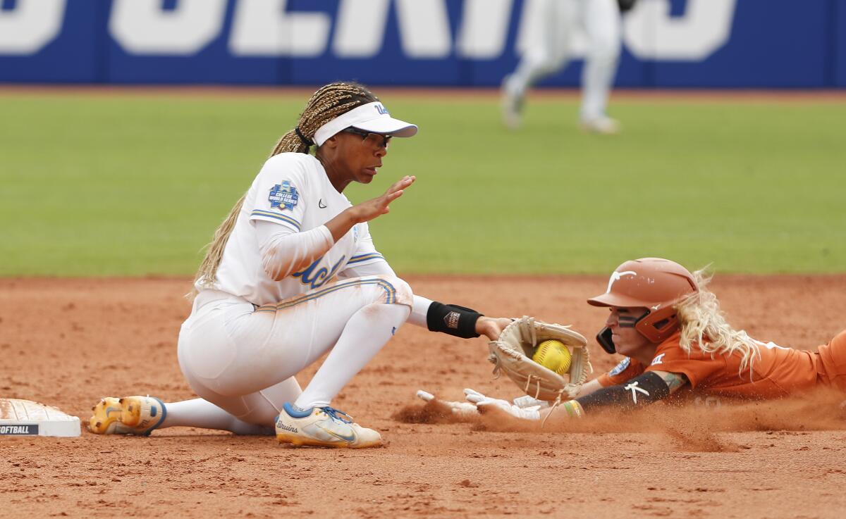 Texas outfielder Isabella Dayton, right, slides into second base in front of UCLA infielder Anna Vines.