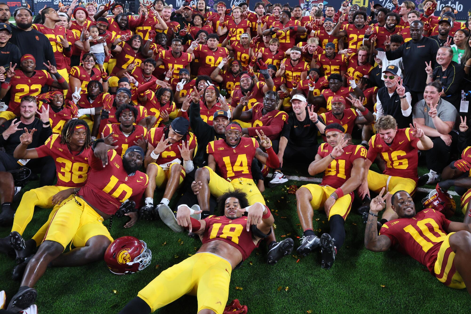 USC coach Lincoln Riley and the team sit on the field together after a 27-20 win over the LSU Tigers.