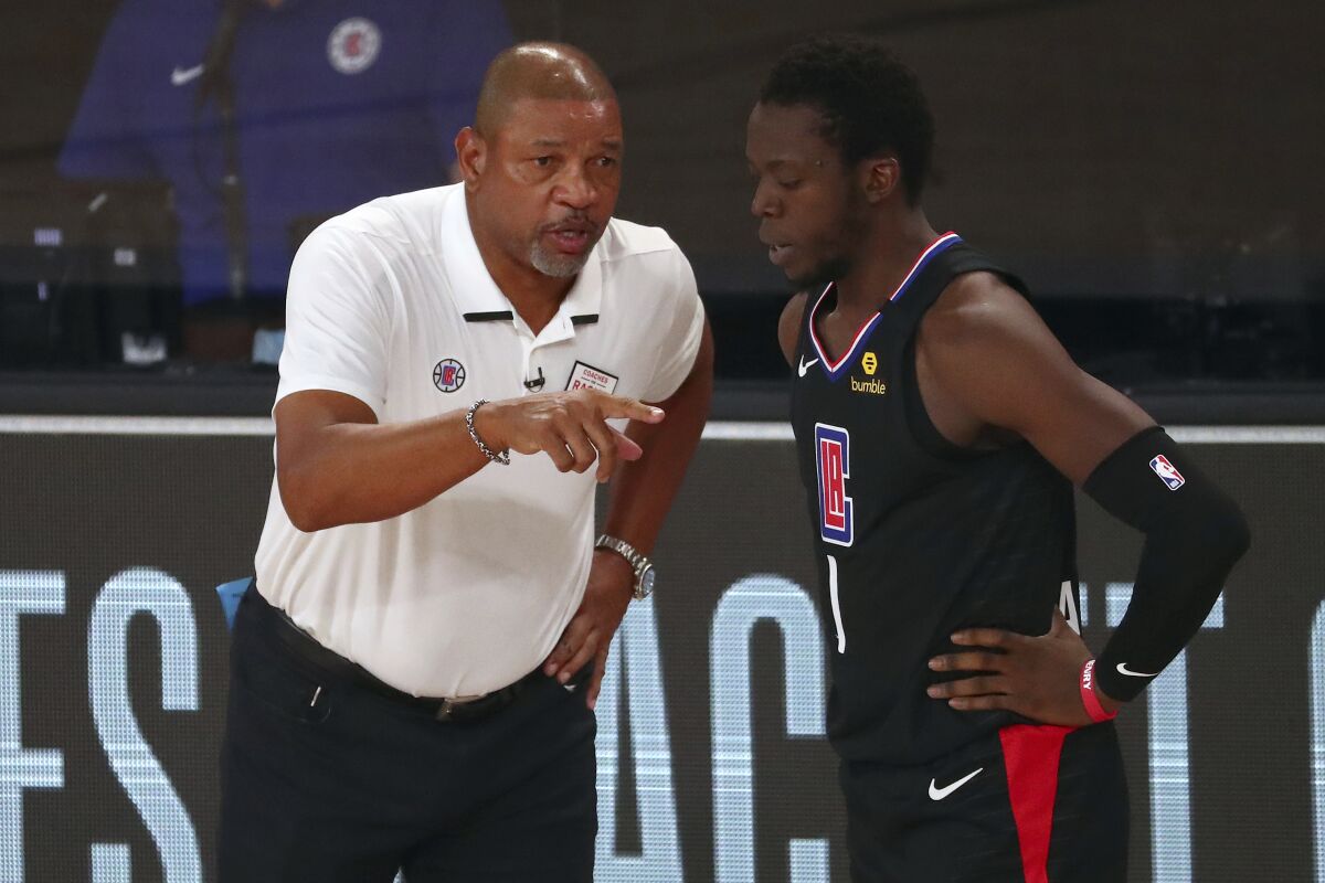 Clippers head coach Doc Rivers talks with guard Reggie Jackson.