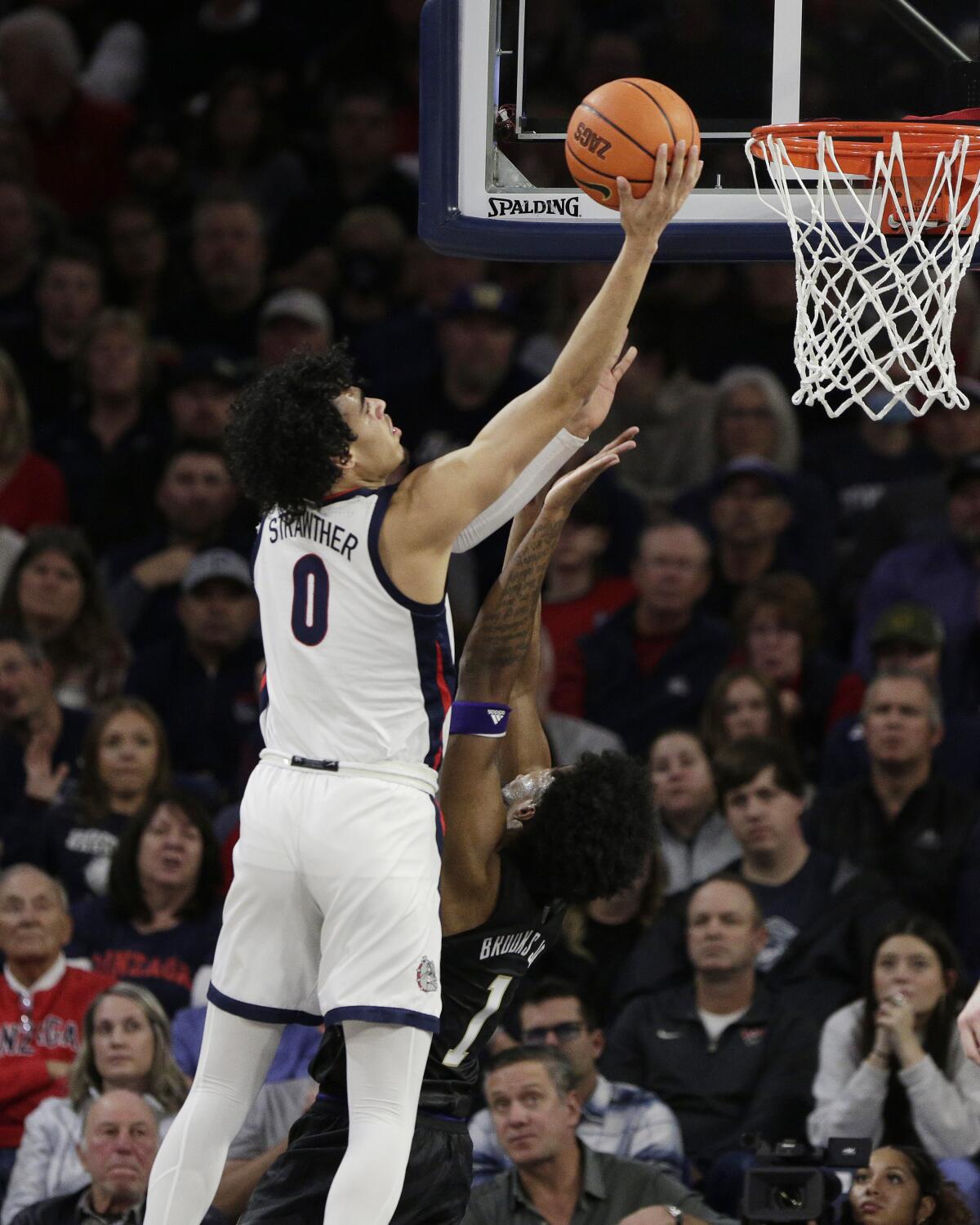 Gonzaga guard Julian Strawther (0) shoots while defended by Washington forward Keion Brooks (1) during the first half of an NCAA college basketball game, Friday, Dec. 9, 2022, in Spokane, Wash. (AP Photo/Young Kwak)