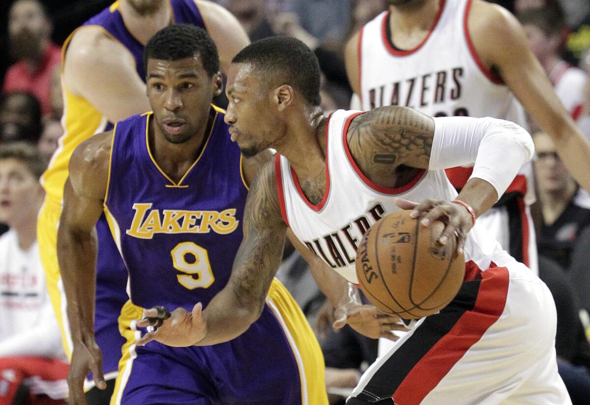 Trail Blazers point guard Damian Lillard tries to drive around Lakers point guard Ronnie Price in the first half.