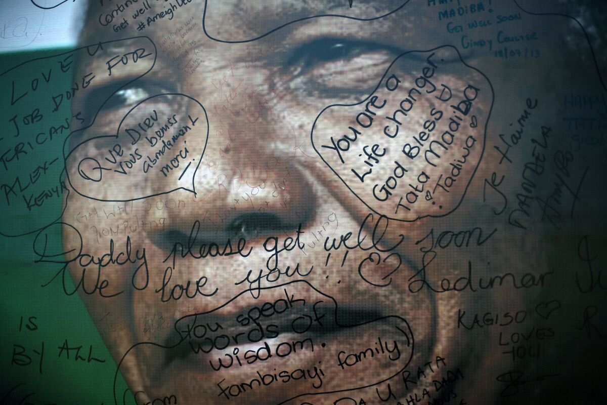 Messages left by supporters are seen on a poster of former South African President Nelson Mandela outside his Soweto home.
