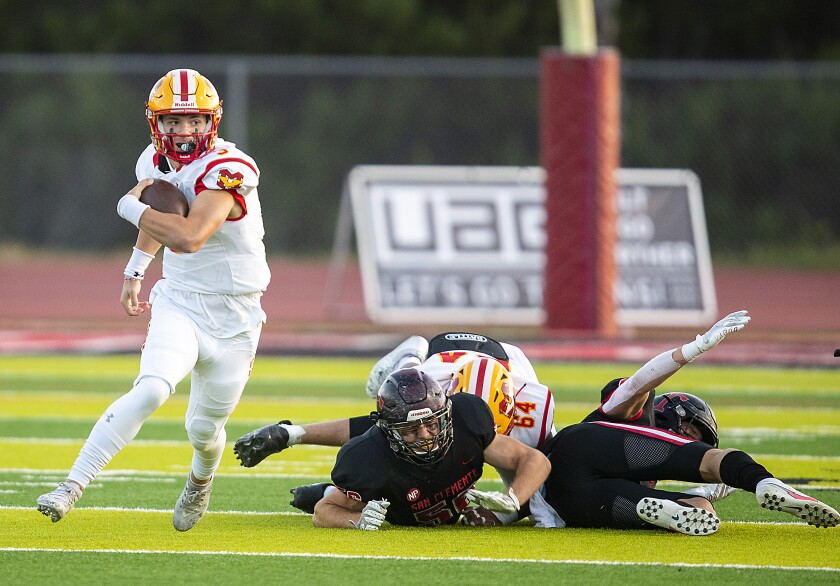 Mission Viejo quarterback Kadin Semonza runs past San Clemente High players in April.