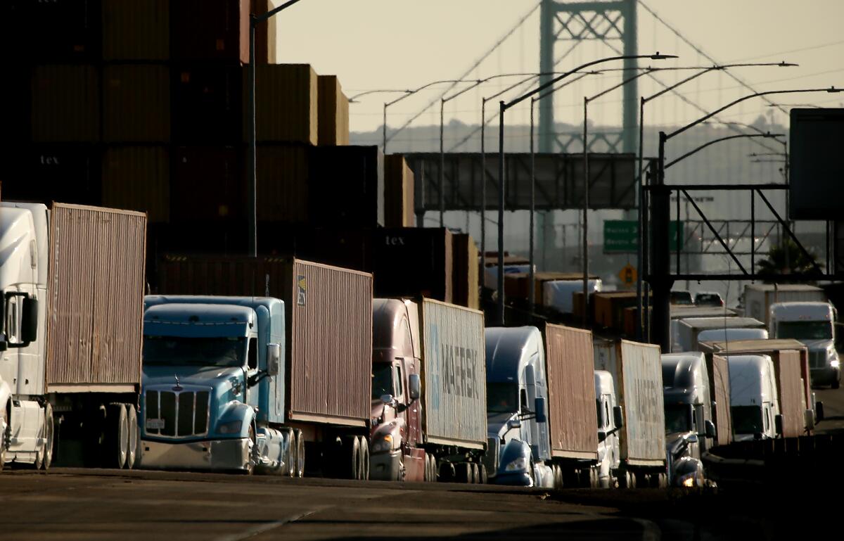 Trucks sit along the side of a road in the Port of Los Angeles.