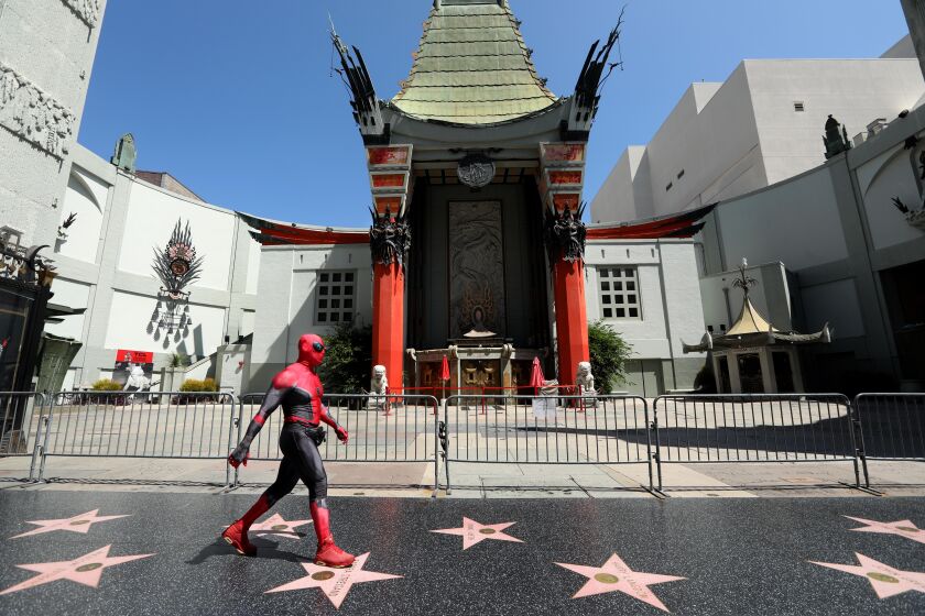 HOLLYWOOD, CA - JULY 28, 2020 - - A street performer, dressed as Spider-Man, looks for customers to pose for photos on a deserted section of Hollywood's Walk of Fame against a backdrop of the TCL Chinese Theatre in Hollywood on July 28, 2020. The COVID-19 pandemic has changed the landscape in LA's Hollywood/Highland corridor. (Genaro Molina / Los Angeles Times)