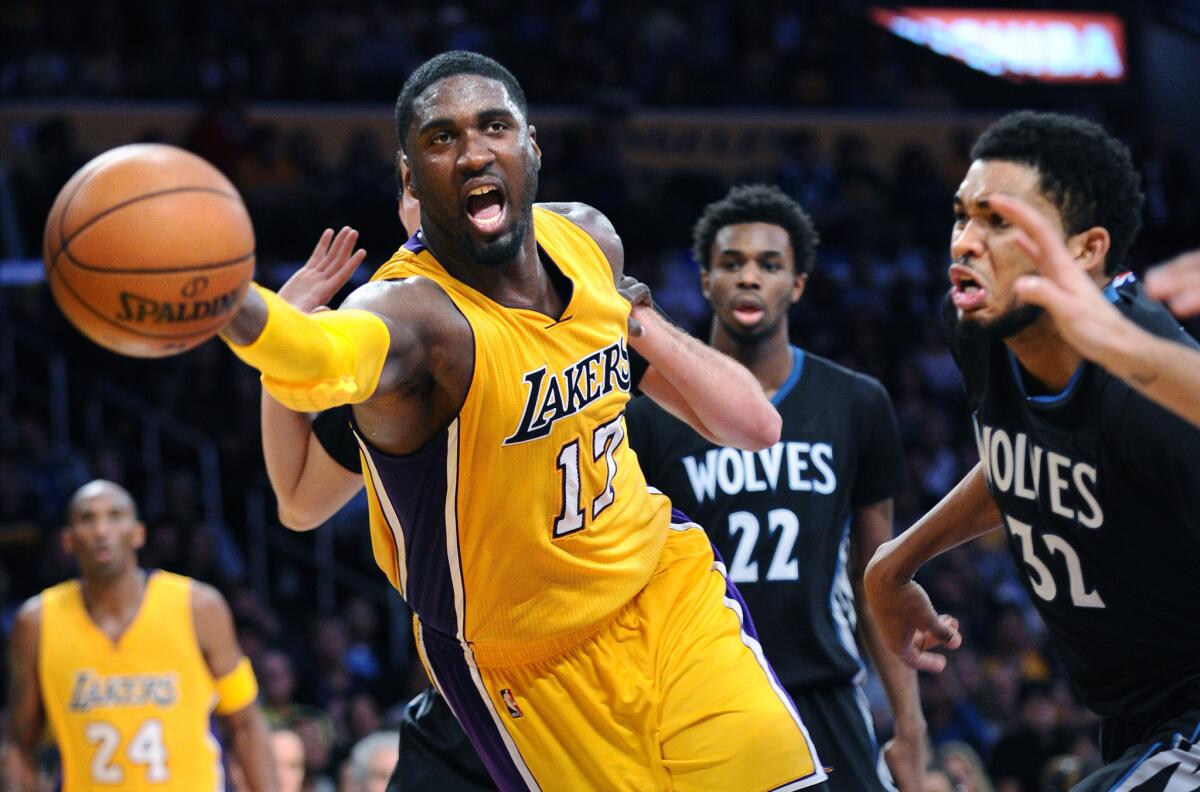 Lakers center Roy Hibbert tries to save the ball from going out of bounds in front of Timberwolves center Karl-Anthony Towns (32).