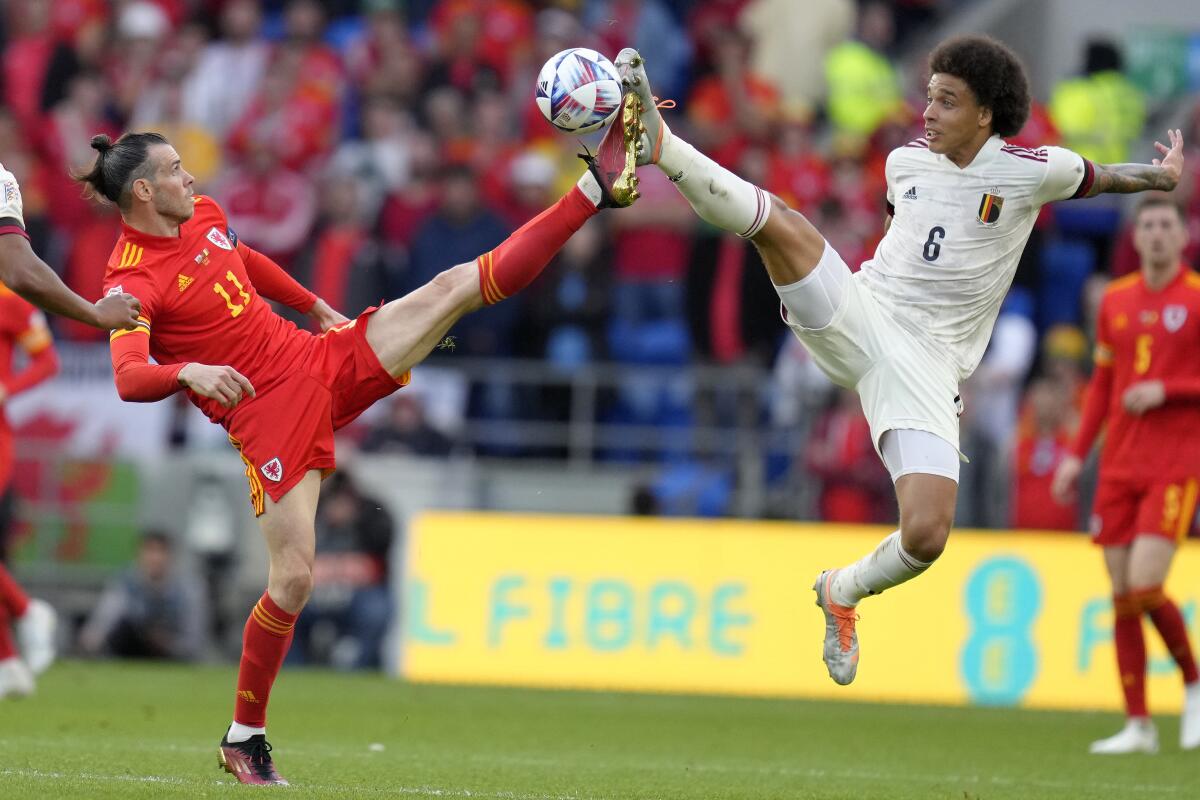 Wales' Gareth Bale , left, and Belgium's Axel Witsel challenge for the ball during the UEFA Nations League soccer match between Wales and Belgium at the Cardiff City stadium in Cardiff, Wales, Saturday, June 11, 2022. (AP Photo/Kirsty Wigglesworth)