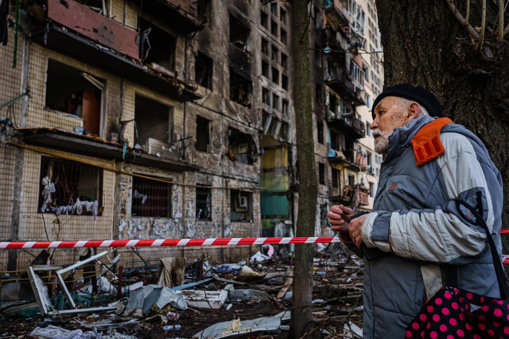 A man looks on at the damaged to apartment building in the Obolon neighborhood of Irpin, Ukraine.
