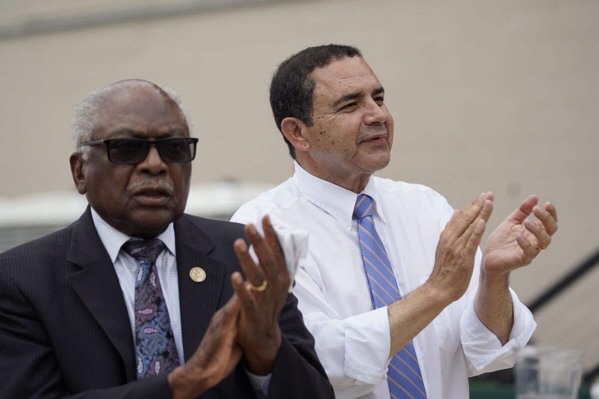 Reps. James Clyburn, left, and Henry Cuellar clap while attending a rally