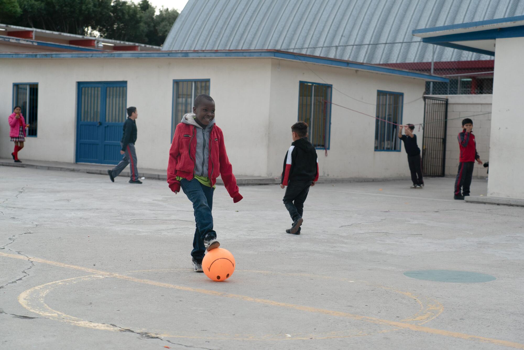 A boy plays soccer during recess.