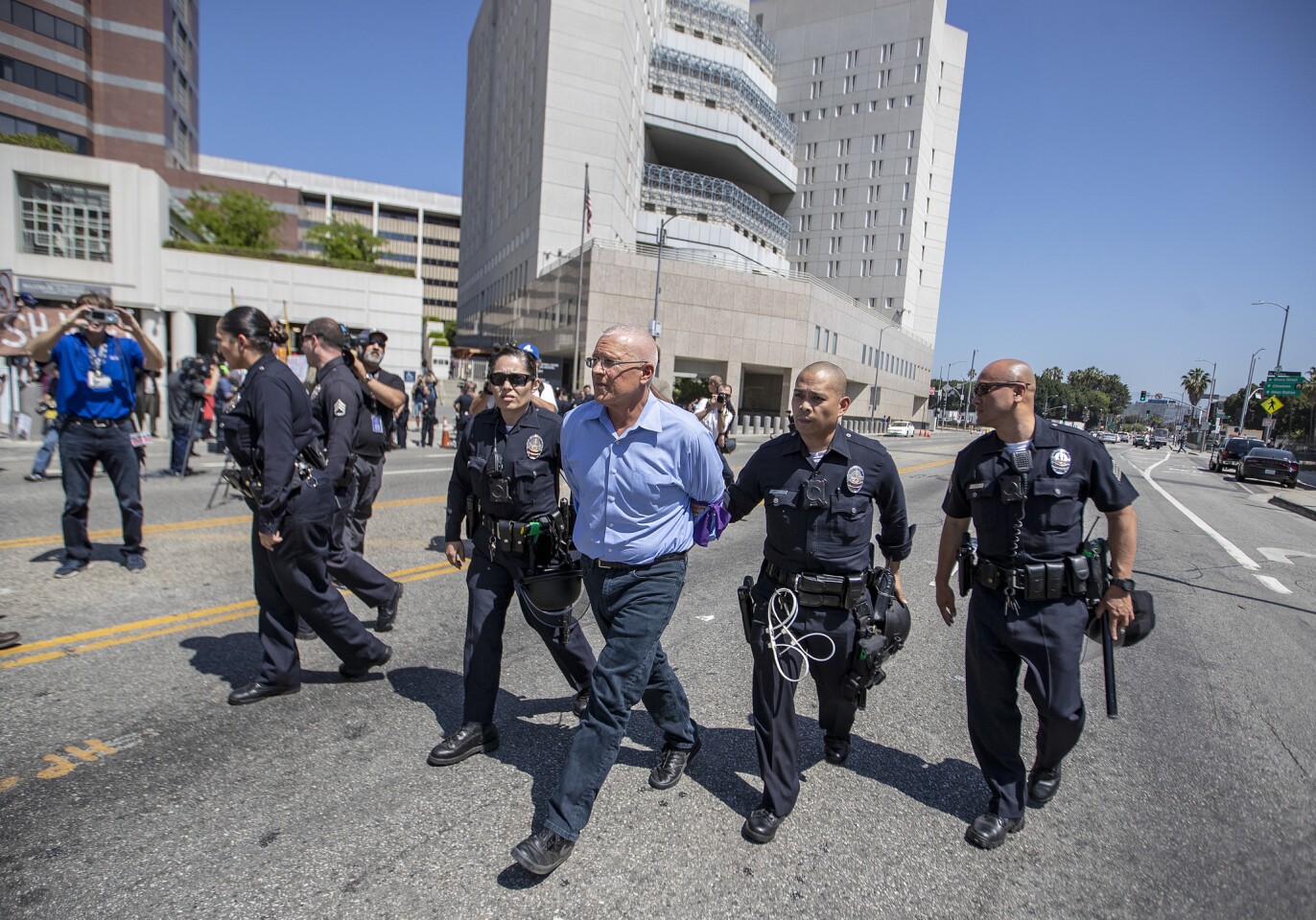 Los Angeles Police Department officers arrest Los Angeles City Councilman Mike Bonin along with more than a dozen other protesters who blocked the entrance to the Metropolitan Detention Center in Los Angeles on Monday.