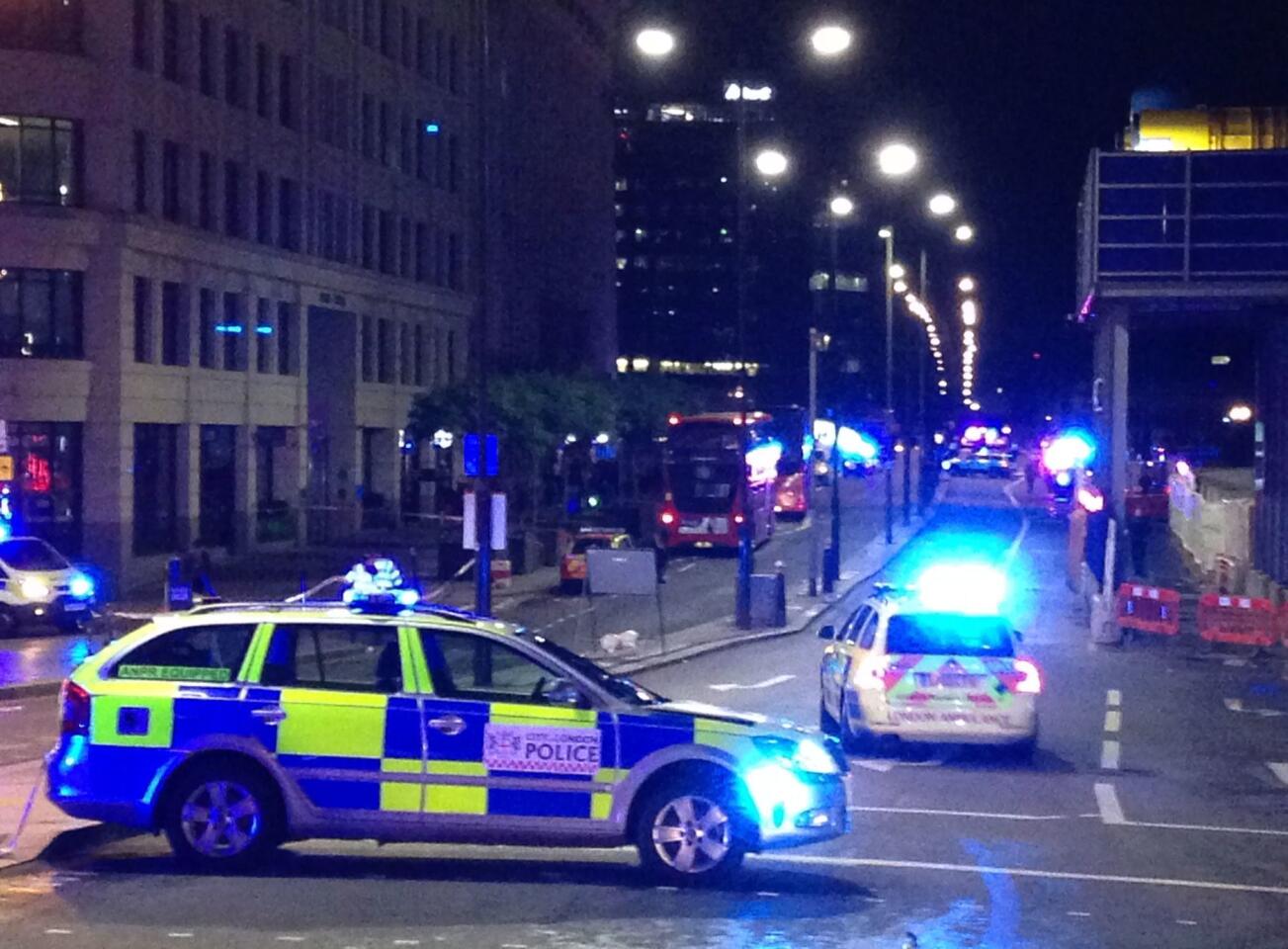 Police cars block the entrance to London Bridge after reports of the attack.