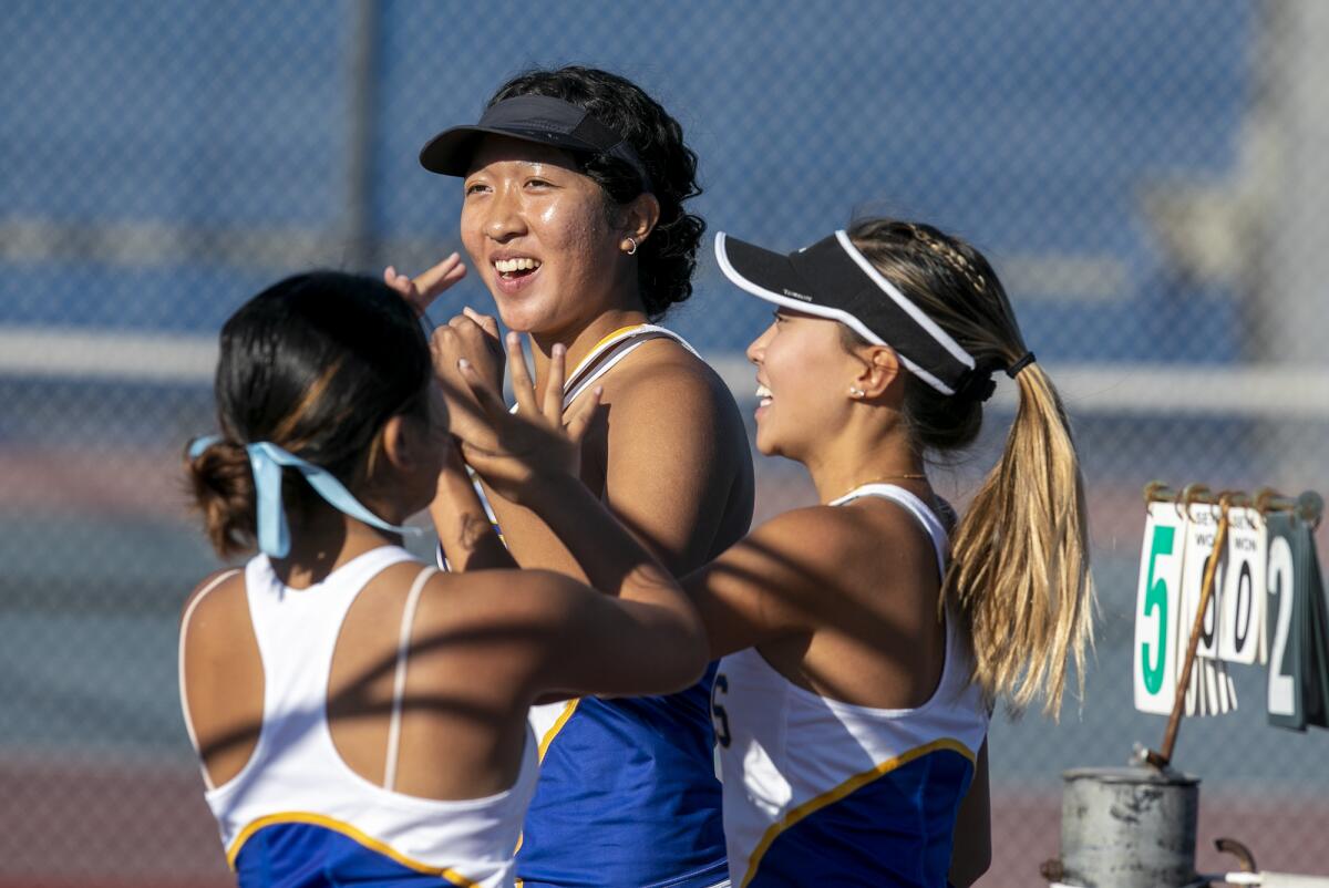 Fountain Valley's Anh Thu Truong, center, and Rene Do celebrate with a teammate after winning their first set.