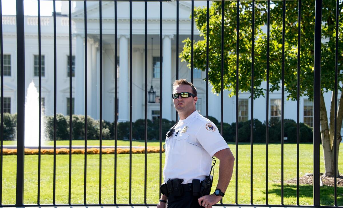 A Secret Service officer stands in front of the White House. A Michigan woman was arrested Thursday for wearing a gun during a protest outside the White House, authorities said.