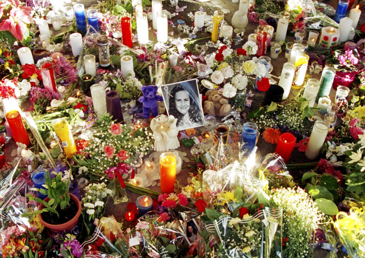 Flowers and candles surround a photo of 12-year-old Polly Klaas.  