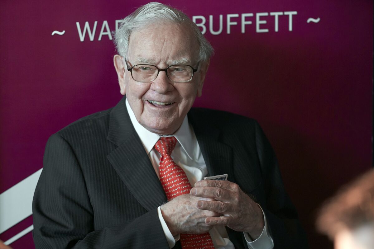 FILE - In this May 5, 2019, file photo Warren Buffett, Chairman and CEO of Berkshire Hathaway, smiles as he plays bridge following the annual Berkshire Hathaway shareholders meeting in Omaha, Neb. Buffett's company pared back its holdings in financial firms further during the first quarter and also halved its new investment in Chevron. Berkshire Hathaway Inc. provided an update on its U.S. stock holdings in a filing with regulators Monday, May 17, 2021. Many investors follow Berkshire's holdings closely because of Buffett's remarkably successful record. (AP Photo/Nati Harnik, File)