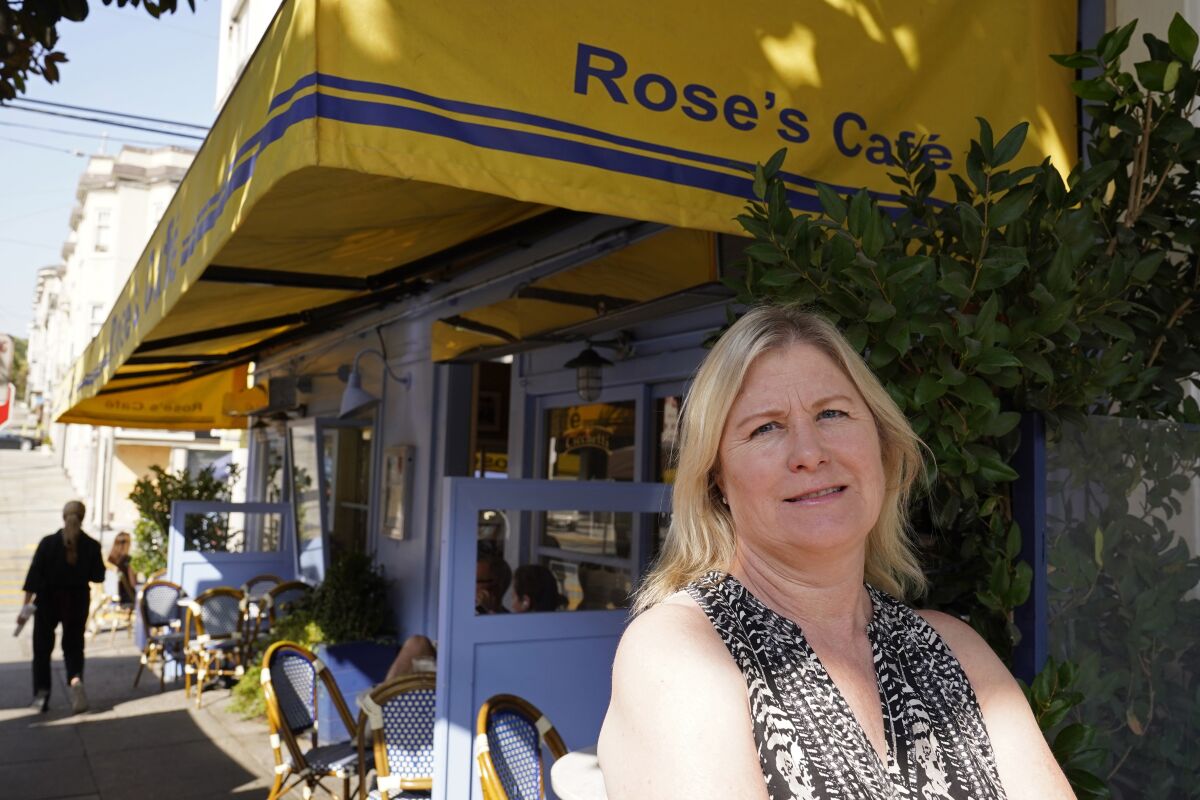 FILE - In this Sept. 28, 2020 file photo, Laurie Thomas poses outside of her Rose's Cafe restaurant, Sept. 28, 2020, in San Francisco. California's landmark ballot measure that keeps a lid on property taxes by tying them to the most recent purchase price is facing one of the biggest challenges in its 42-year history. Proposition 15 on Tuesday's ballot would reassess commercial and industrial properties every three years. Thomas, who owns two restaurants in San Francisco, said Proposition 15 would be "one more nail in the coffin" of her industry. (AP Photo/Eric Risberg, File)