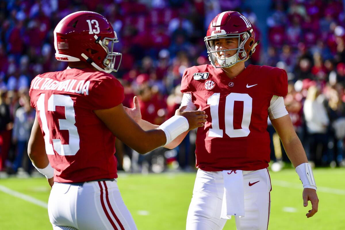 FILE - In this Nov. 9, 2019, file photo, Alabama quarterbacks Tua Tagovailoa (13) and Mac Jones (10) shake hands before an NCAA football game against LSU in Tuscaloosa, Ala. The former Alabama teammates face each other when the Miami Dolphins and Tagovailoa, take on Jones and the New England Patriots on Sunday, Sept. 12, 2021, in Foxborough, Mass. (AP Photo/Vasha Hunt, File)