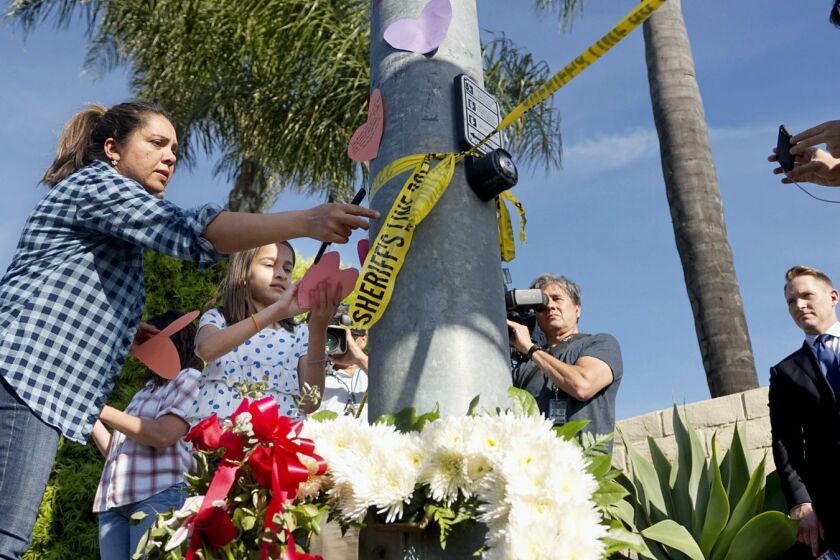 A woman and a young girl place notes on a light post near flowers across the street from the Chabad of Poway Synagogue after a shooting on April 27, 2019 in Poway, California. - A gunman opened fire at a synagogue in California, killing one person and injuring three others including the rabbi as worshippers marked the final day of Passover, officials said Saturday, April 27, 2019. The shooting in the town of Poway came exactly six months after a white supremacist shot dead 11 people at Pittsburgh's Tree of Life synagogue -- the deadliest attack on the Jewish community in the history of the United States. (Photo by SANDY HUFFAKER / AFP)SANDY HUFFAKER/AFP/Getty Images ** OUTS - ELSENT, FPG, CM - OUTS * NM, PH, VA if sourced by CT, LA or MoD **