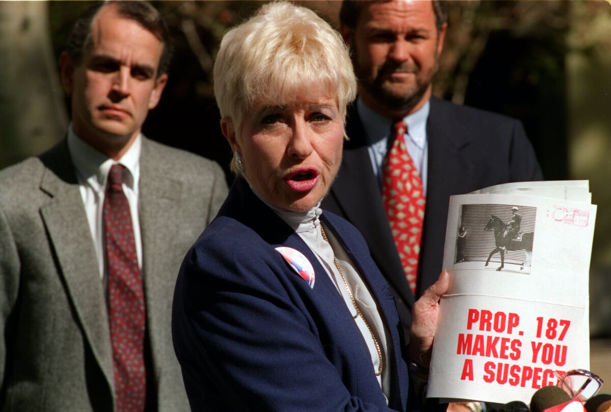 Barbara Coe displays literature distributed by an anti-Proposition 187 group in 1994 