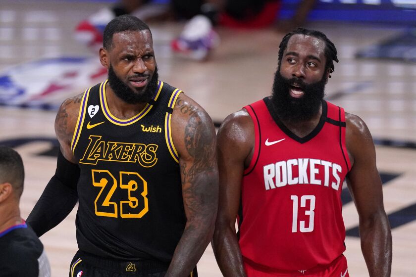 Los Angeles Lakers' LeBron James (23) and Houston Rockets' James Harden (13) react to a call.